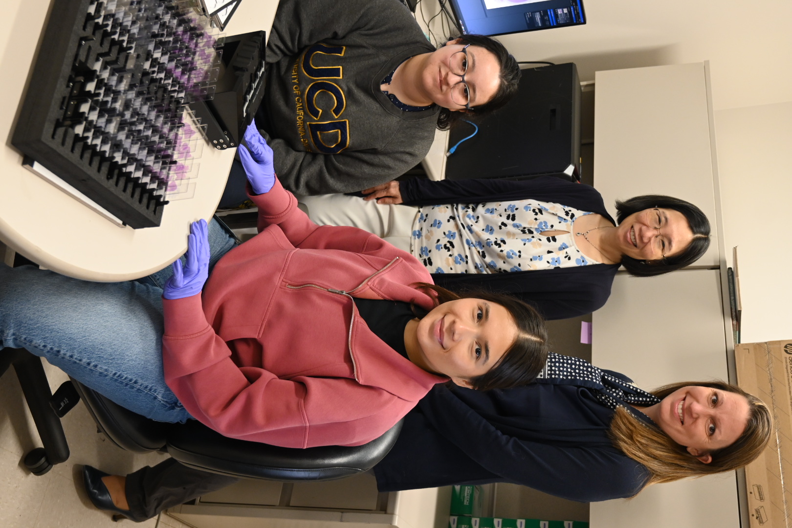 Chen-Nee Chuah and Brittany Dugger sit with two Ph.D. students.