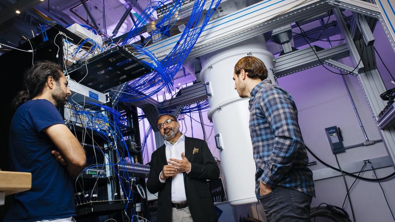 Irfan Siddiqi of UC Berkeley stands with two graduate students in a quantum computer lab.