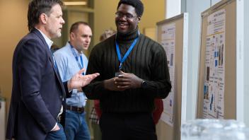three men pictured at a poster session