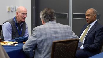 three men seated talking