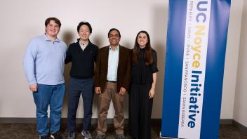 research group stands near UC Noyce Initative banner
