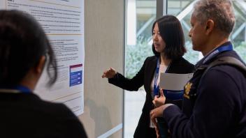 three people talk at a post