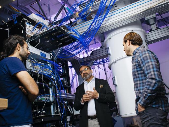 Irfan Siddiqi of UC Berkeley stands with two graduate students in a quantum computer lab.