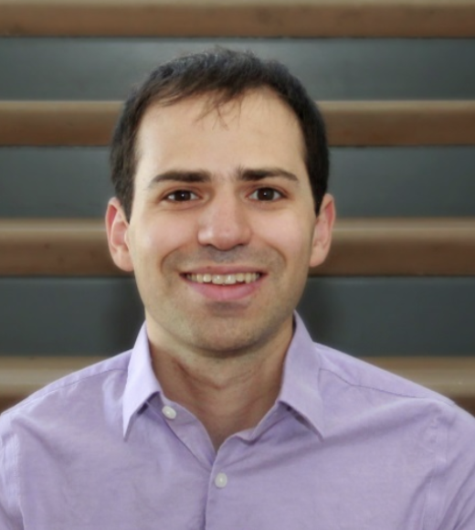 portrait of daniel epstein. he is wearing a lavender collared shirt.