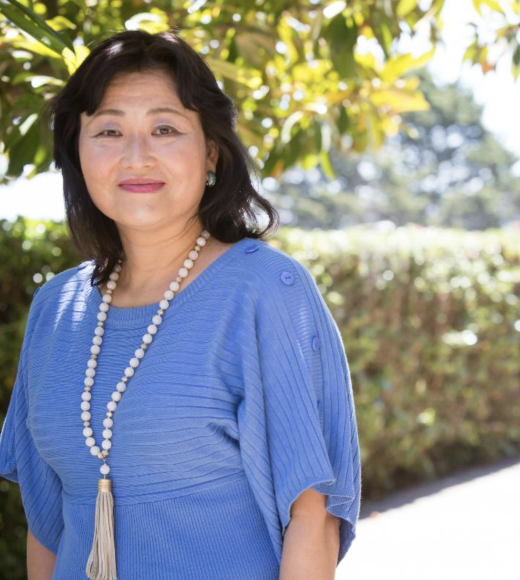 portrait of Yoshimi Fukuoka, RN, PhD, FAAN outside wearing a light blue dress and necklace.