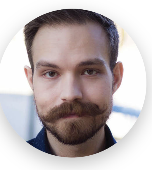 portrait of Alex Bower. Young white male with a handle bar mustache and closely trimmed beard.