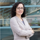 Marina Radulaski environmental portrait standing with arms crossed in a light tan sports coat