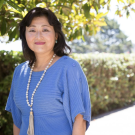 portrait of Yoshimi Fukuoka, RN, PhD, FAAN outside wearing a light blue dress and necklace.