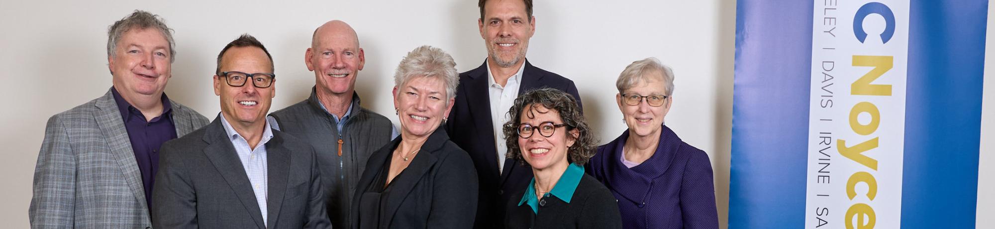 Five vice chancellors of research stand in group with member of Robert Noyce trust by UC Noyce Initiative banner.
