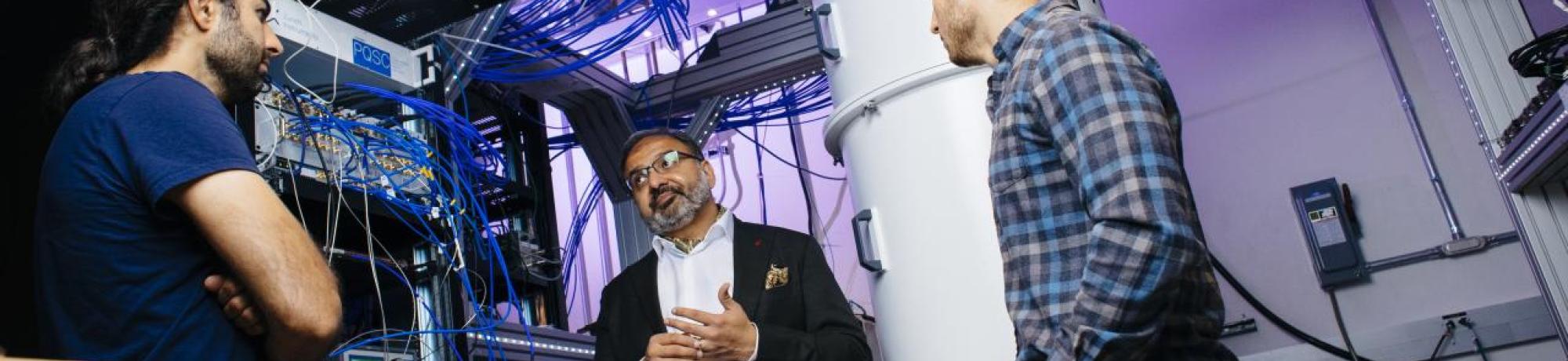 Irfan Siddiqi of UC Berkeley stands with two graduate students in a quantum computer lab.